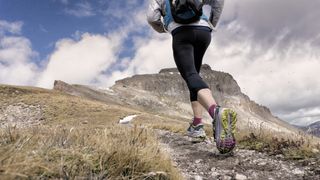 Woman running up mountain trail