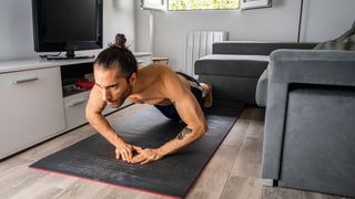 a photo of a man doing a diamond push up in his living room