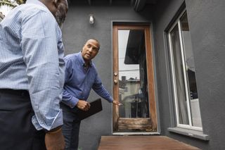 Home inspector talking with home owner in back yard