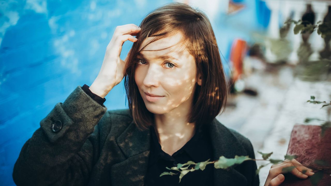 Young woman scratches her head