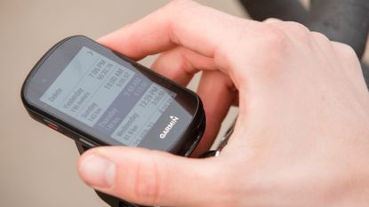 Male cyclist looking at the data on his cycling computer