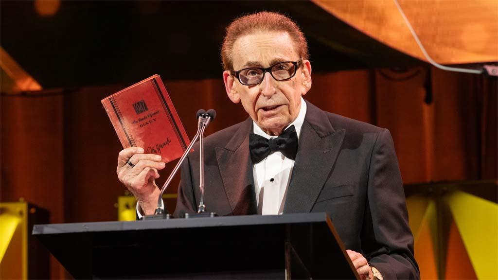 Dr. Joel N. Meyers, founder and executive chair of AccuWeather, holds up one of his childhood weather diaries.