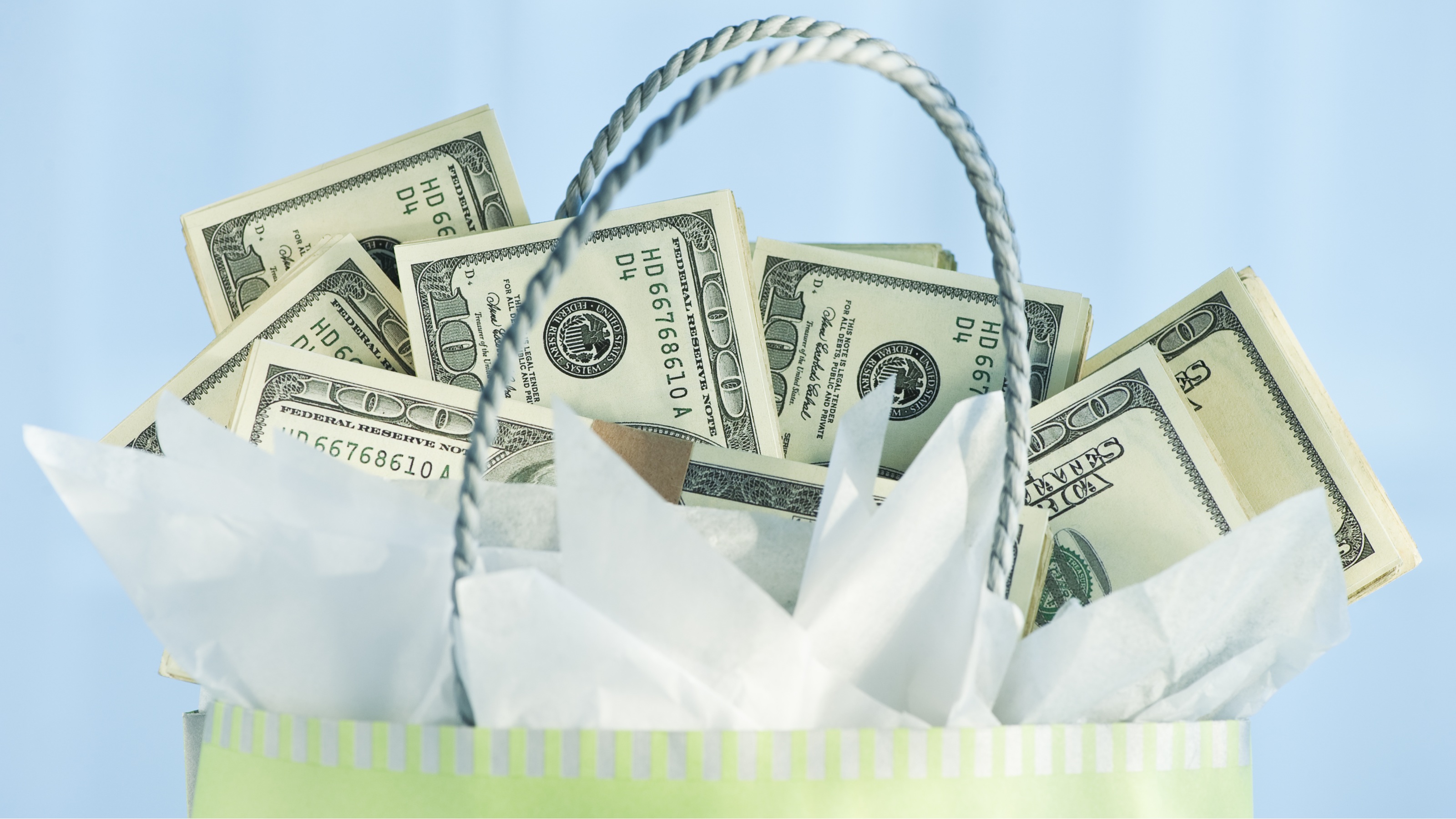 A gift bag with hundred-dollar bills sticking out of the top.