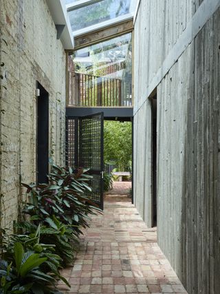 Outside space inbeween structures at Stockroom Cottage by Architects EAT
