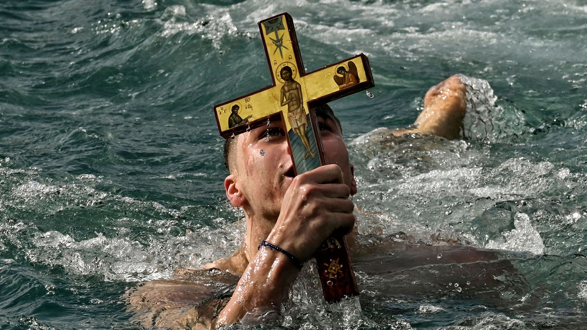 
                                A swimmer seizes a wooden cross during the Epiphany Day celebrations at the port of Corinth, Greece
                            