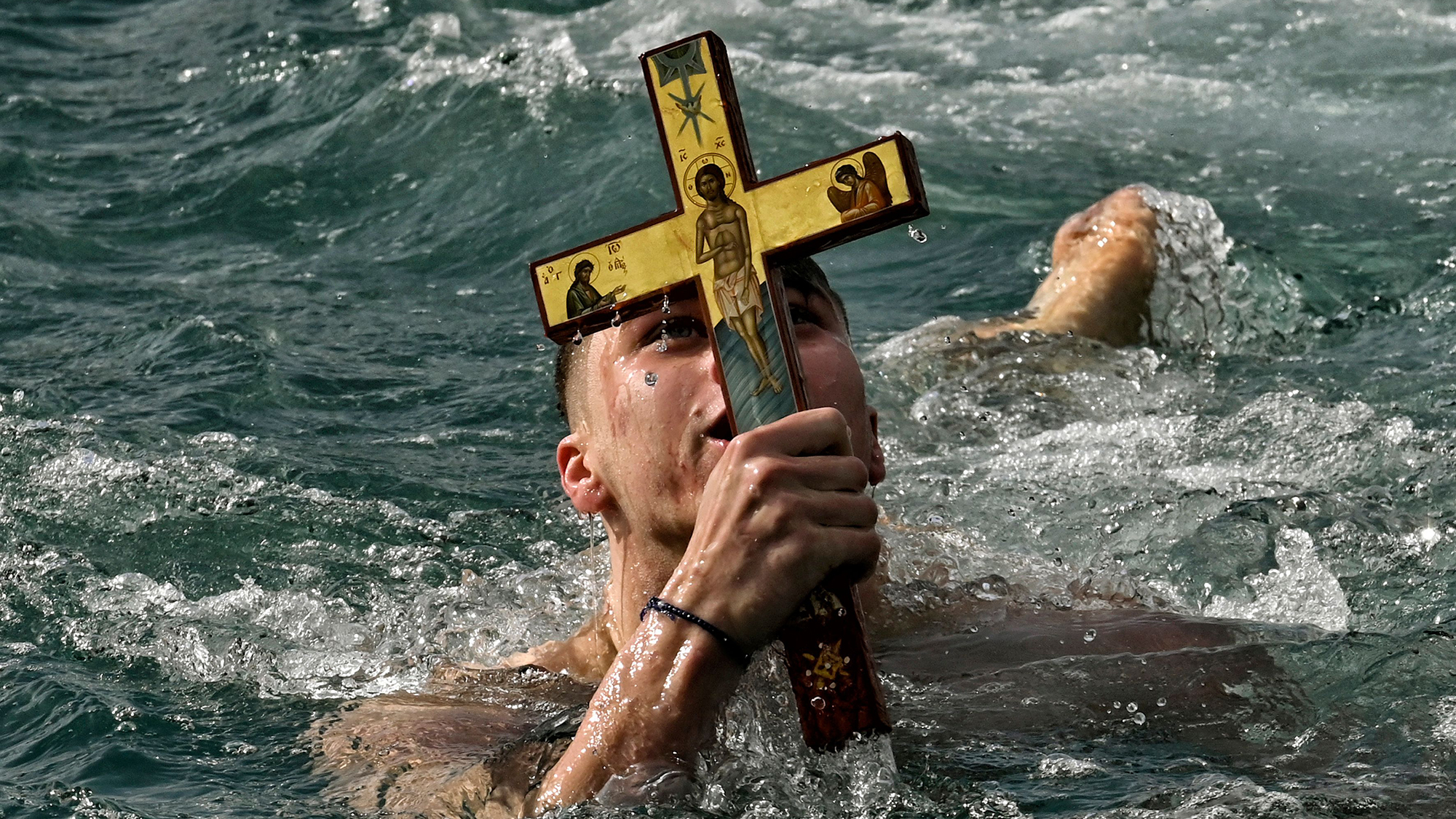 A swimmer seizes a wooden cross during the Epiphany Day celebrations at the port of Corinth, Greece