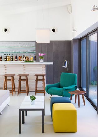 Room with green armed chair and stools