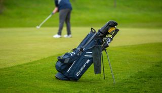 The Cobra Ultradry Pro 2023 Stand Bag with a man putting him