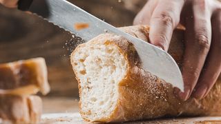 Loaf of bread being cut with a bread knife
