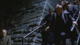 A group of people running down a staircase at night in The Exorcist