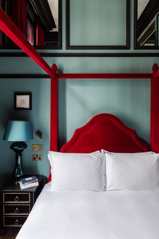 Blued bedroom with red velvet four poster bed