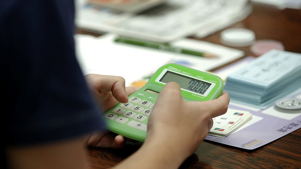 A person using a calculator to solve a math problem.