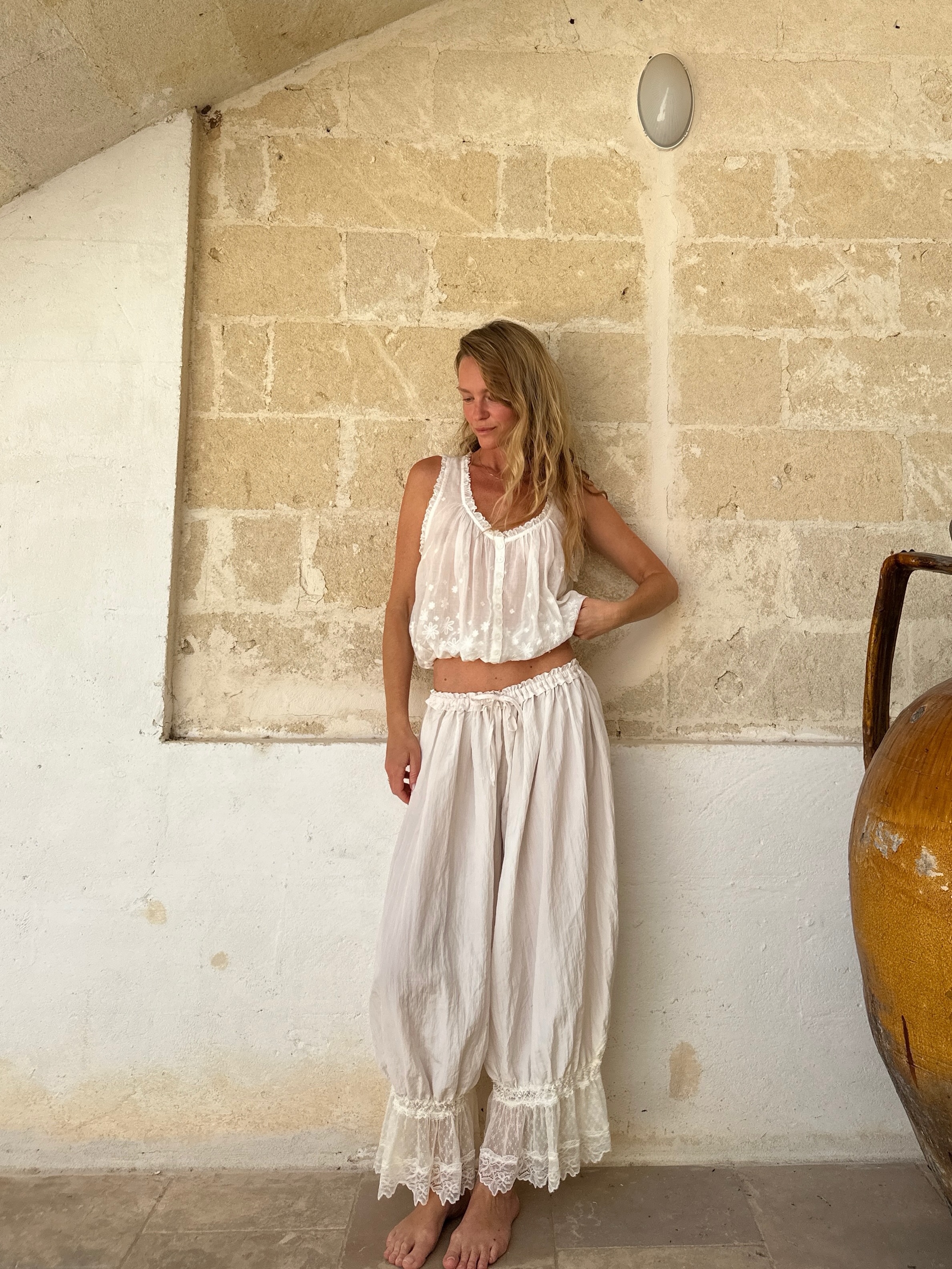 Jeanette Madsen in white embroidered hem pants.