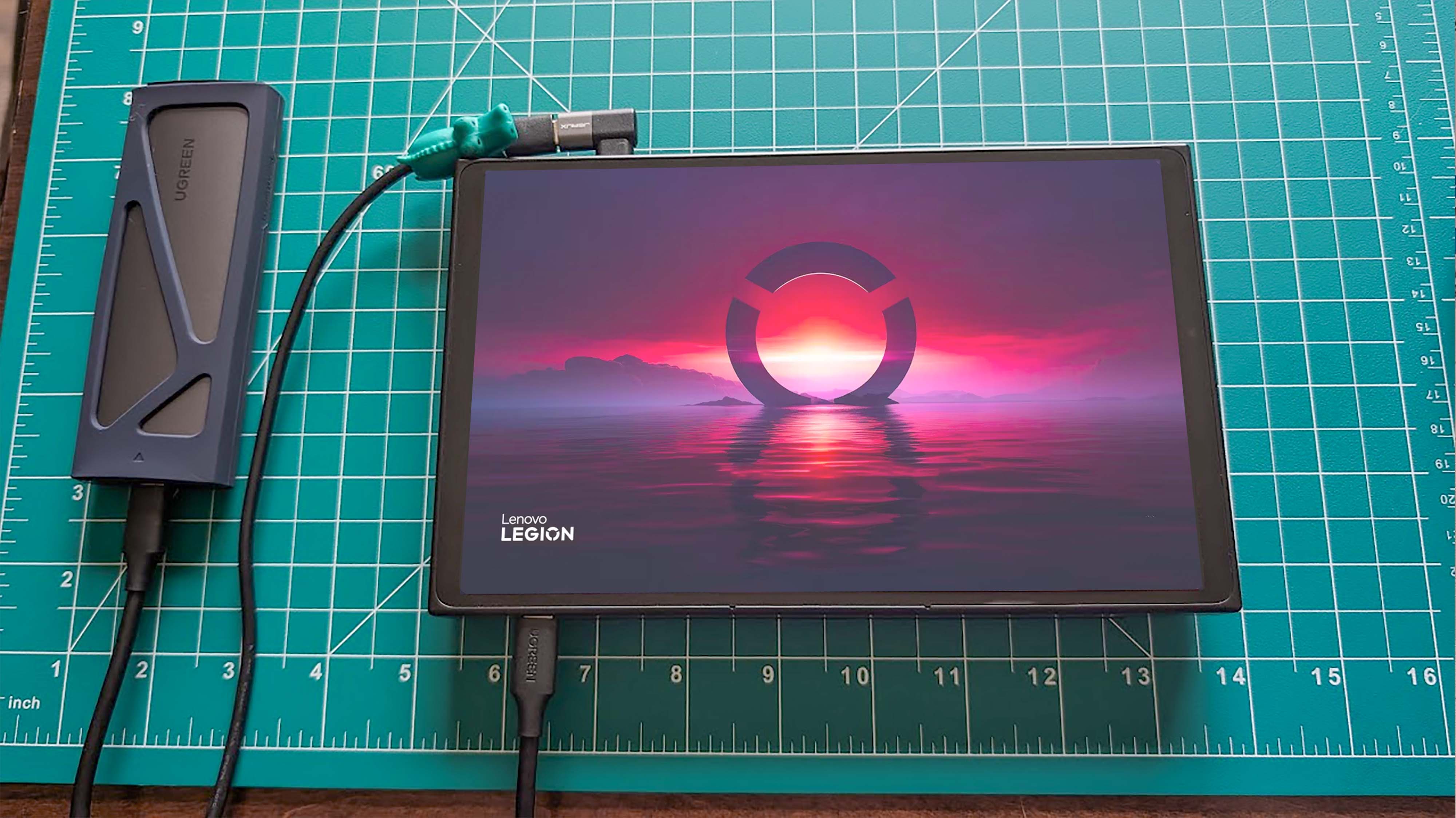 A Lenovo Legion Go plugged into its power cable and the UGREEN SSD Enclosure.