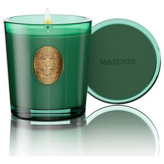 A green and gold glass pine candle