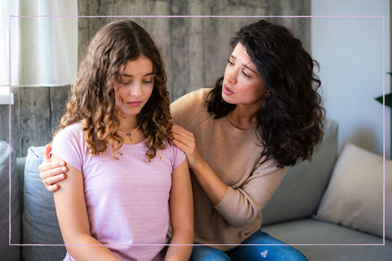 Mother trying to talk to teenage daughter while both sat on the sofa