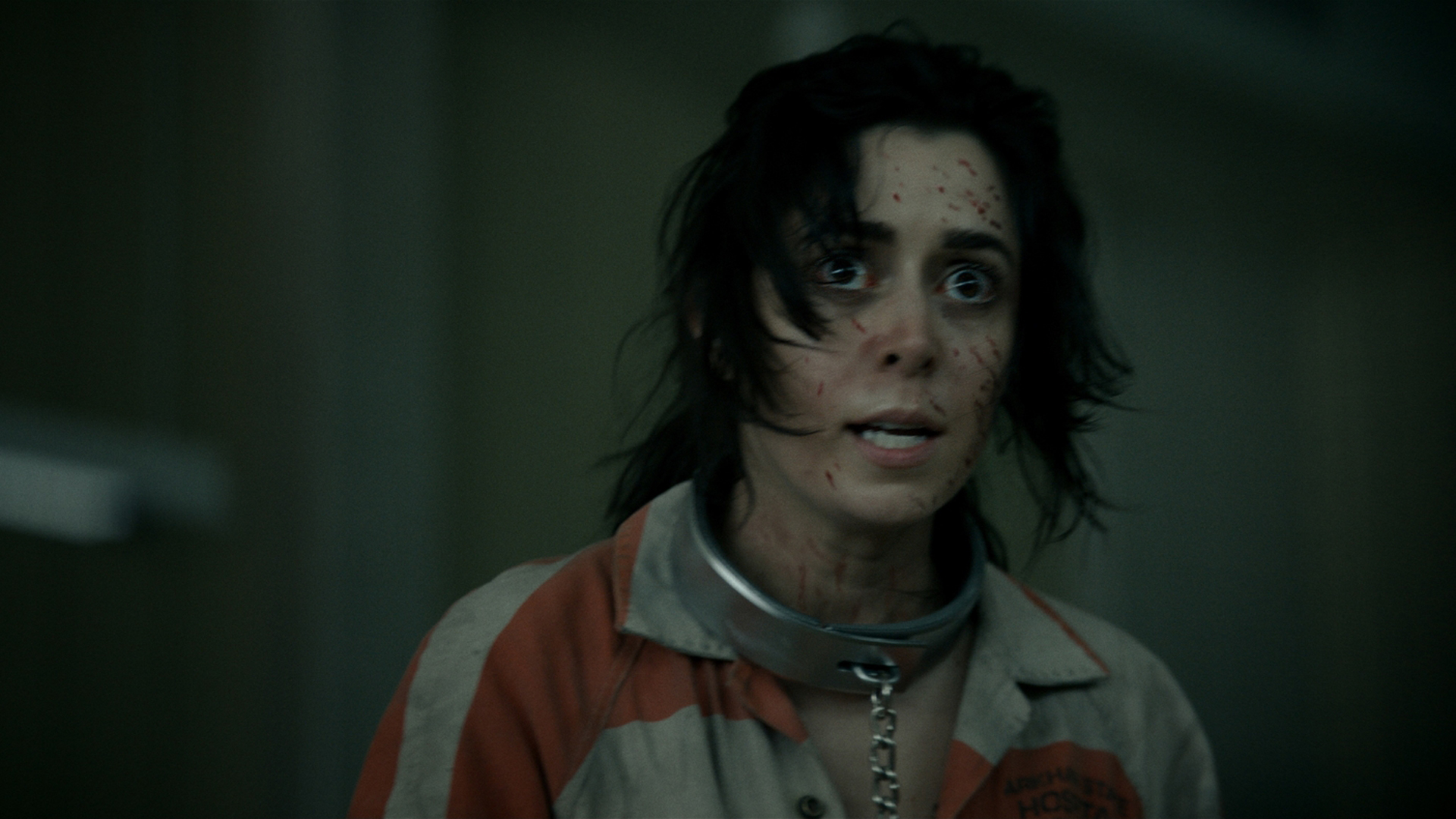 A frenzied and bloodied Sofia Falcone wearing a prison suit and chains in The Penguin