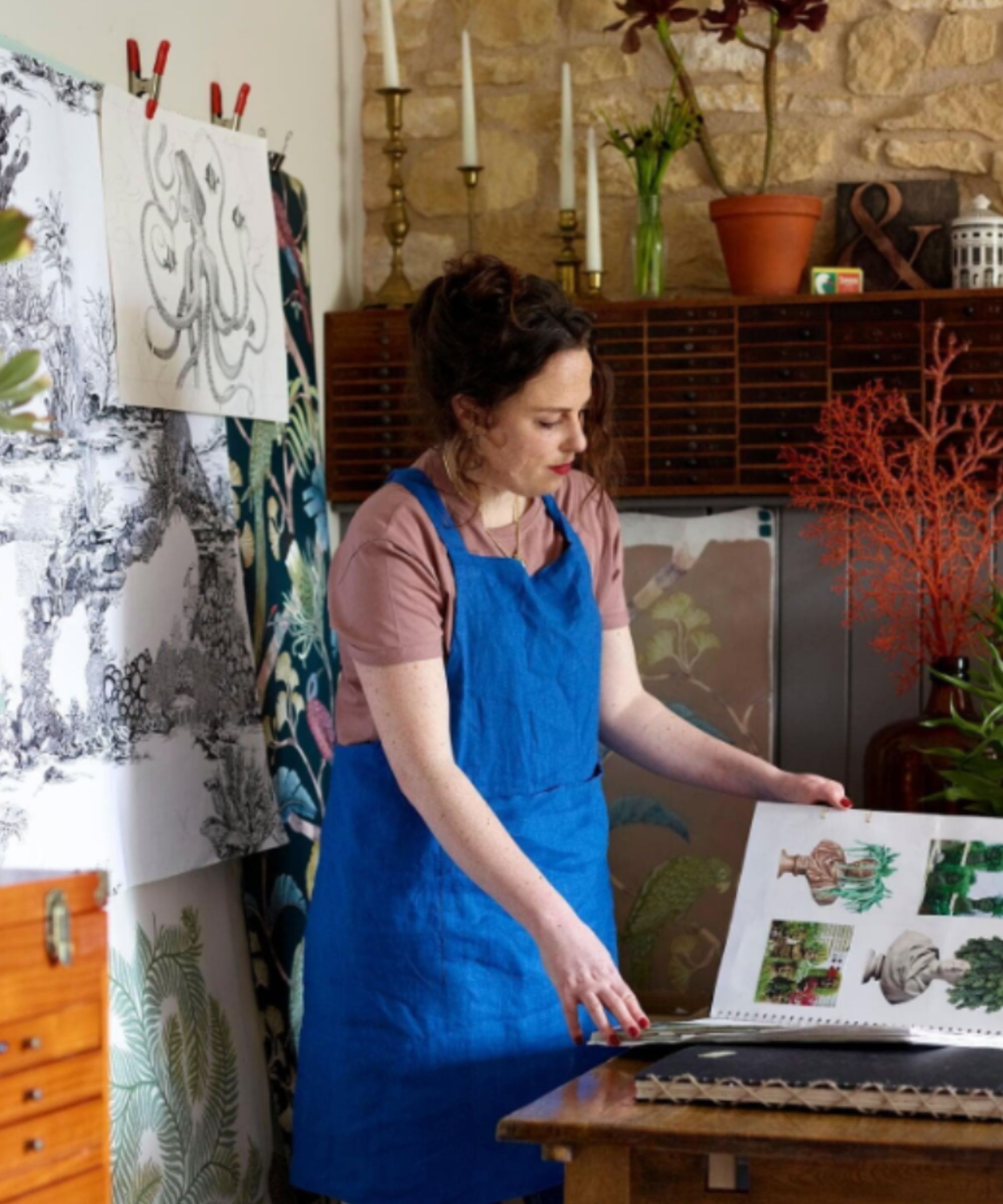 Wallpaper designer flicking through cut outs in a sketch book
