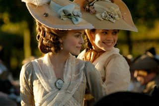 keira knightley as Georgiana Cavendish in period dressing and large hats on a carriage in the movie the duchess