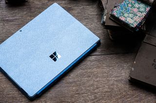 Closed blue Microsoft Surface Pro 9 Liberty Special Edition on wooden surface
