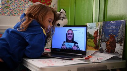 A child takes part in teaching at home on a laptop.