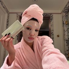 Photo of a woman wearing a face mask holding French macarons 