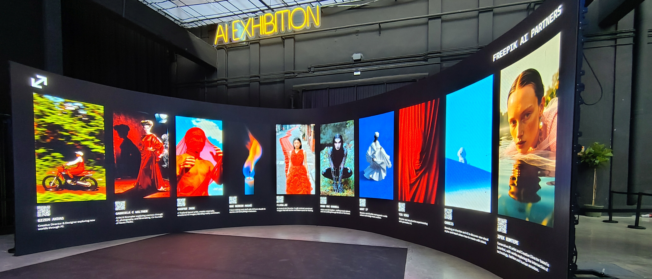 A wraparound screen showing multiple AI images under a banner reading &#039;AI Exhibition&#039; during Freepik Upscale Malaga