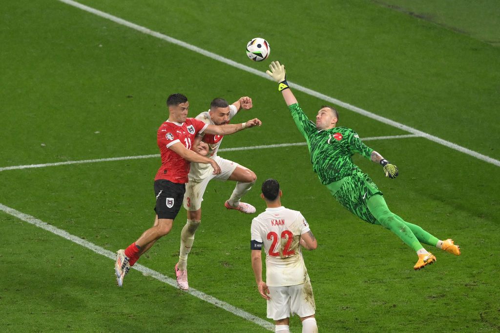 Mert Gunok of Turkiye dives to make a save as Christoph Baumgartner of Austria competes for a header with Merih Demiral of Turkiye during the UEFA EURO 2024 round of 16 match between Austria and Turkiye at Football Stadium Leipzig on July 02, 2024 in Leipzig, Germany. (Photo by Justin Setterfield/Getty Images)