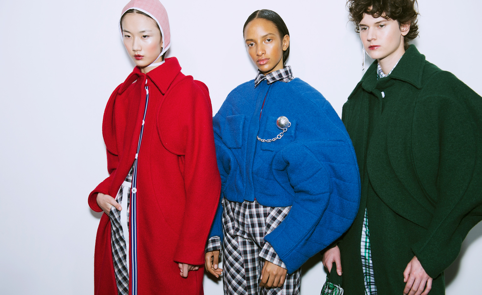 Models wear block colour sweaters with tailored trousers
