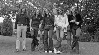 Deep Purple standing in front of a statue in the gardens Clearwell Castle in Gloucestershire