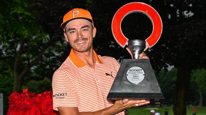 Rickie Fowler lifting the Rocket Mortgage Classic trophy after winning.