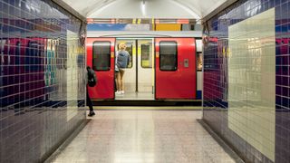 Commuter standing on a train at a London underground tube station, which is run by Transport for London (TfL).