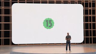 Et skjermbilde fra Google UI 2022 som viser en person på en scene og en Android 13-logo projisert på en scene