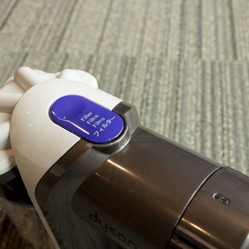 The Dyson V6 detaches from the handle of this stick vacuum cleaner when you press the large blue button.