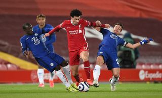 Curtis Jones evades tackles from two Chelsea players