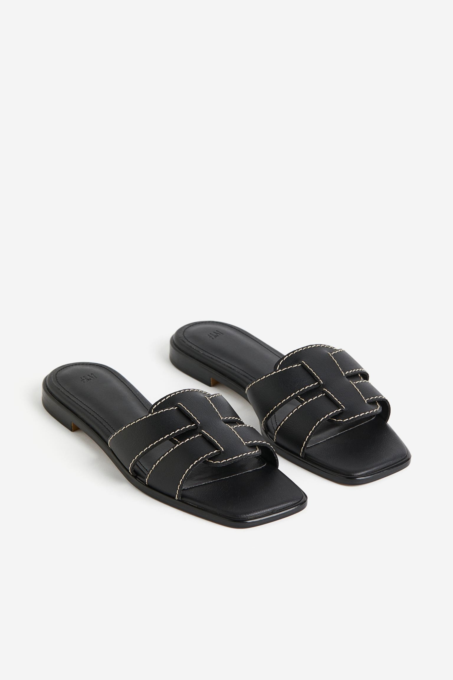 Black flat H&M sandals with white stitching