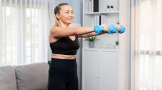 Woman working out with light dumbbells at home