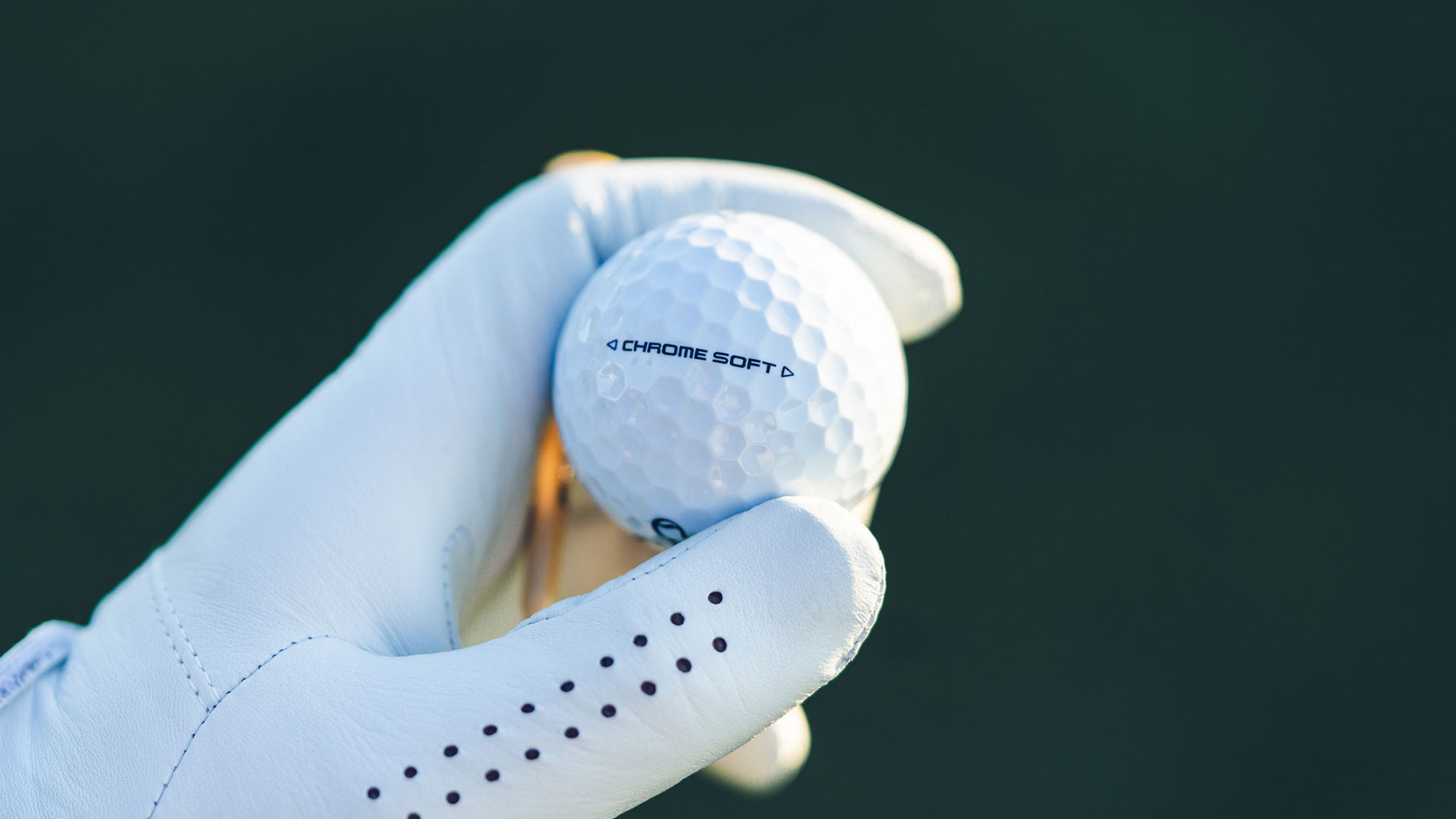 The Callaway Chrome Soft golf ball being held in golfers hand showing chrome soft branding