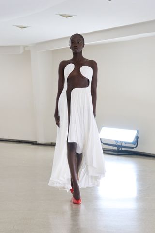 A woman wears an outfit from the S/S 2025 Alaïa collection.