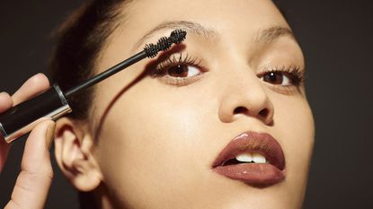 close up of woman applying mascara