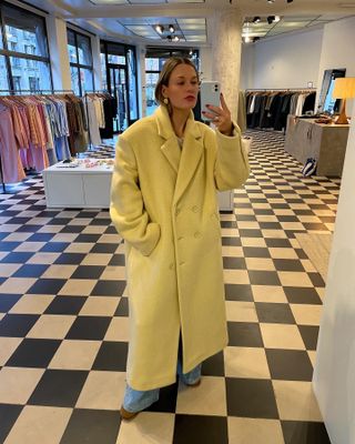 influencer in muted yellow coat