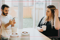 couple sat at table, man is ignoring woman