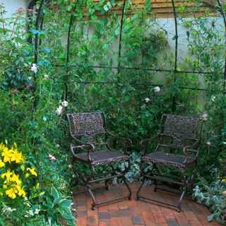 garden area with trellis and chairs