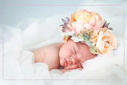 A sleeping baby with flowers on its head