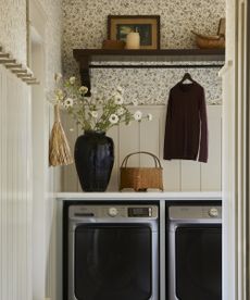 laundry room with floral wallpaper on the wall above the washing machine