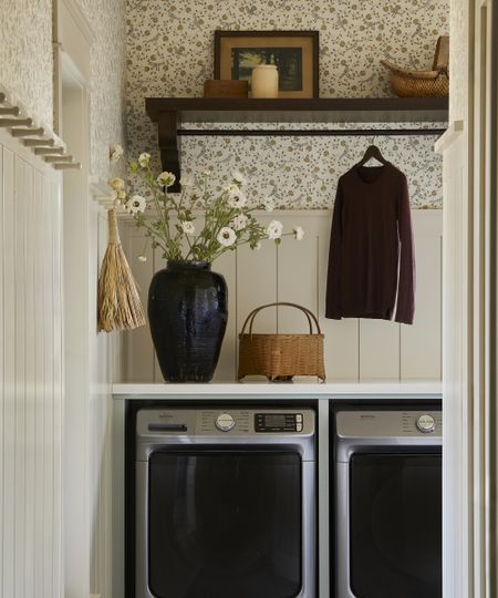 laundry room with floral wallpaper on the wall above the washing machine