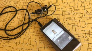 Astell & Kern A&norma SR25 MKII and Audeze Euclid earbuds, on yellow table