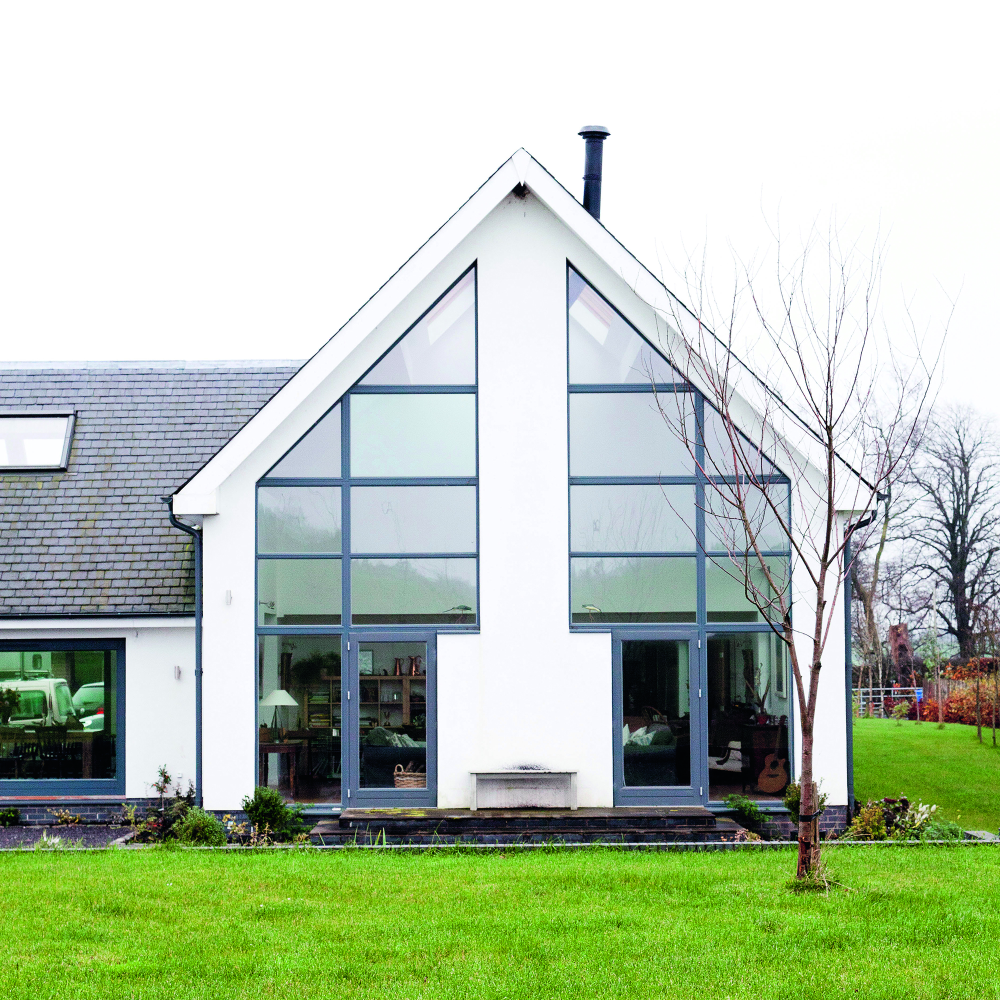house with white wall and garden area