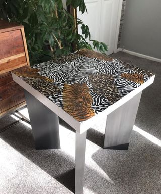 A coffee table upcycle with assortment of animal print motifs applied using decoupage technique