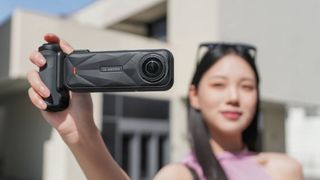 Person holding Insta360 X5 camera and X5 Photography Grip